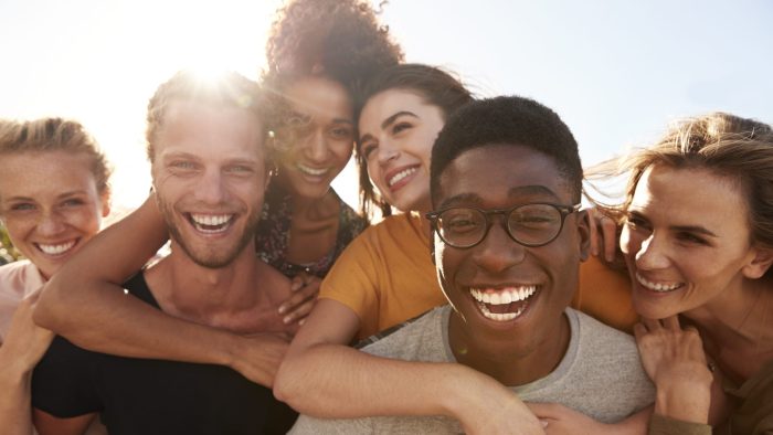 Portrait Of Smiling Young Friends Walking Outdoors Together