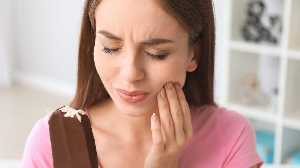 Young Woman With Sensitive Teeth And Cold Ice Cream At Home