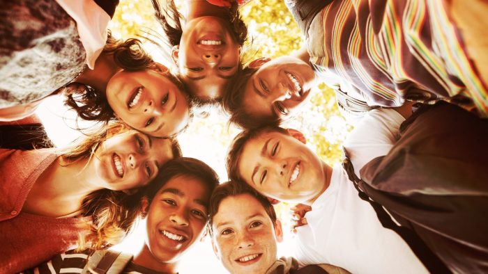 Group of School Kids Forming A Huddle and smiling