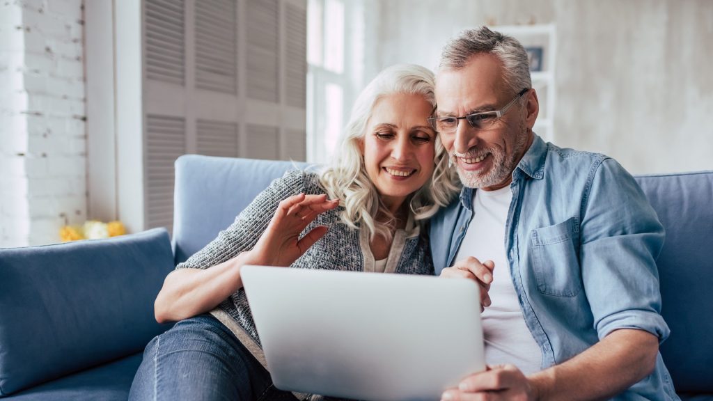 Older couple looking at computer for dental implant info Portage dentist