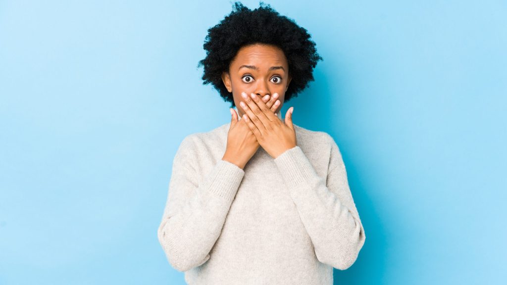 Woman covering bleeding gums at Portage MI family dentist